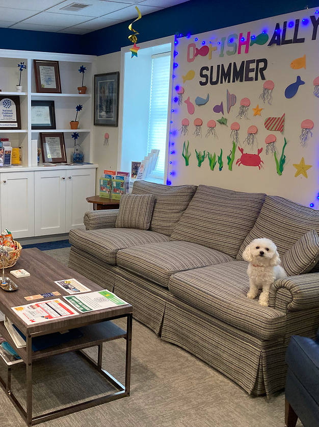 Welcoming lobby with seating and a small white dog.