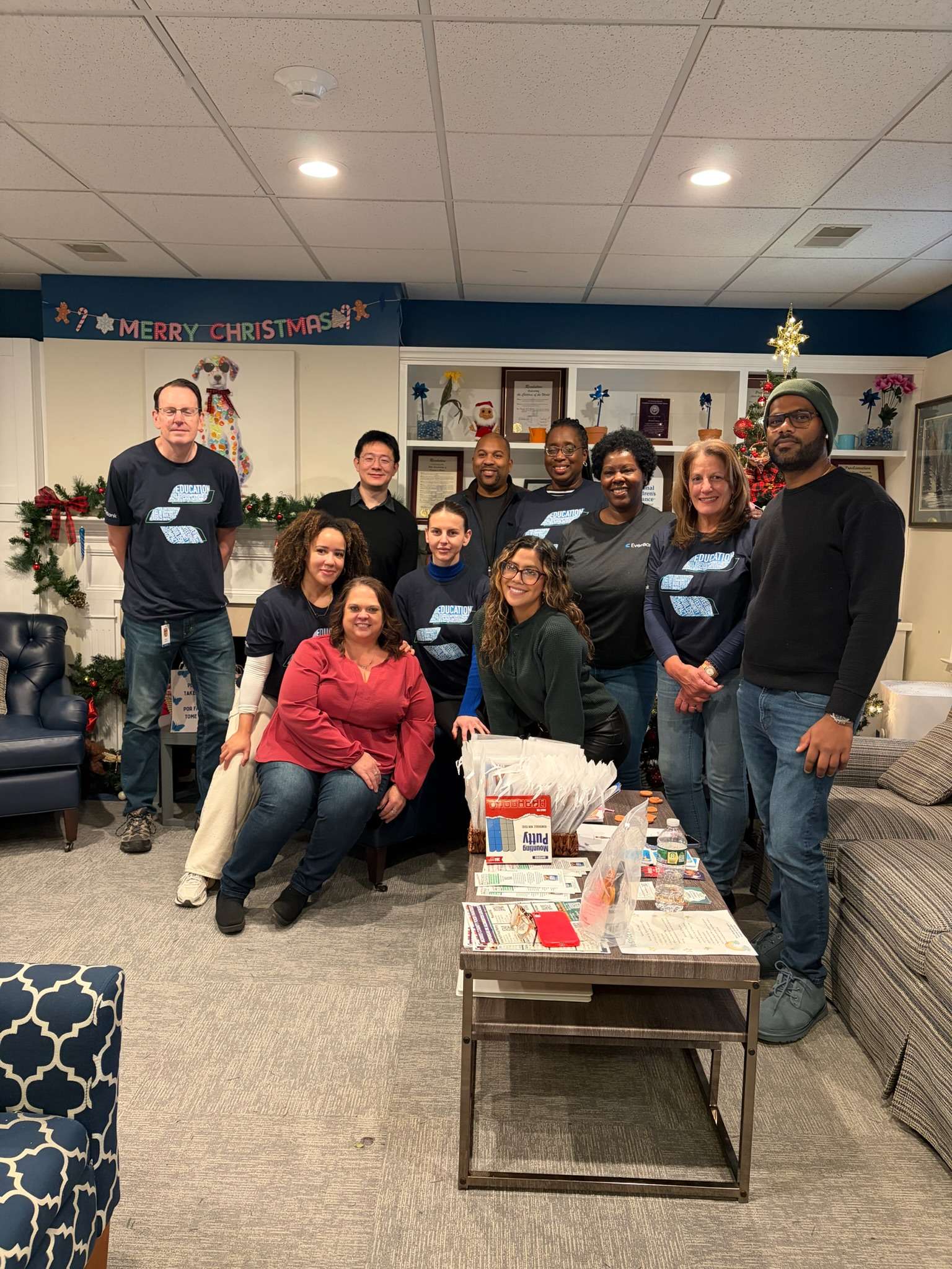Group of volunteers and community supporters posing together with donated supplies.