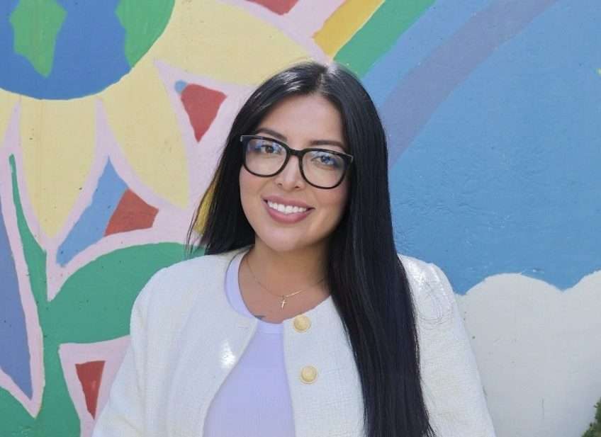 Portrait of Maria Gallmann in front of a colorful mural