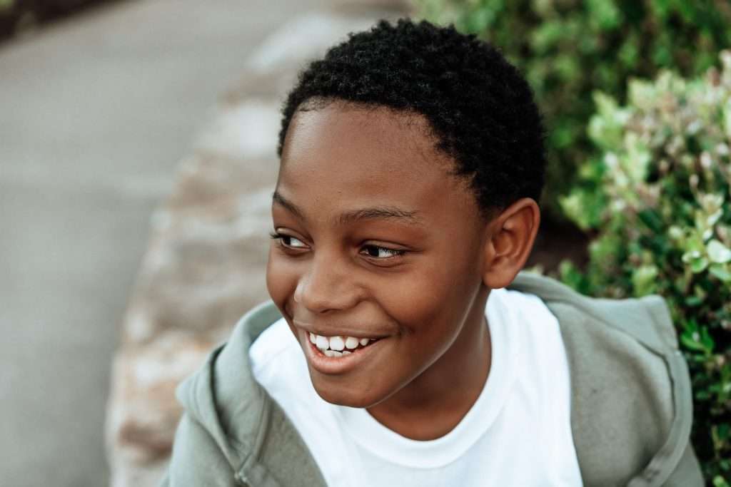 Close-up portrait of a smiling child outdoors.