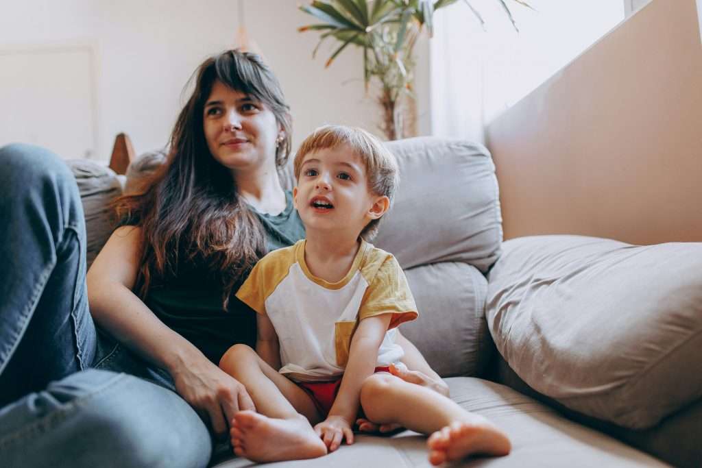 Adult and child sitting together on a couch.