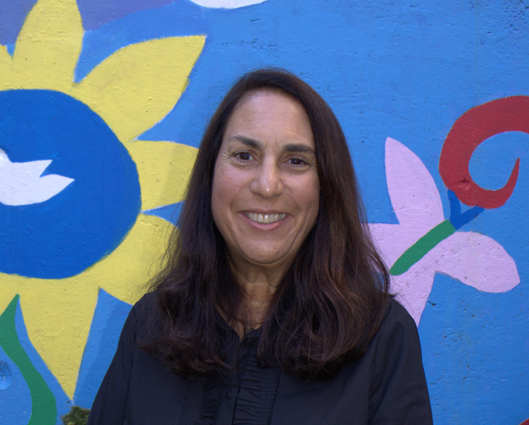 Portrait of Maria in front of a colorful mural