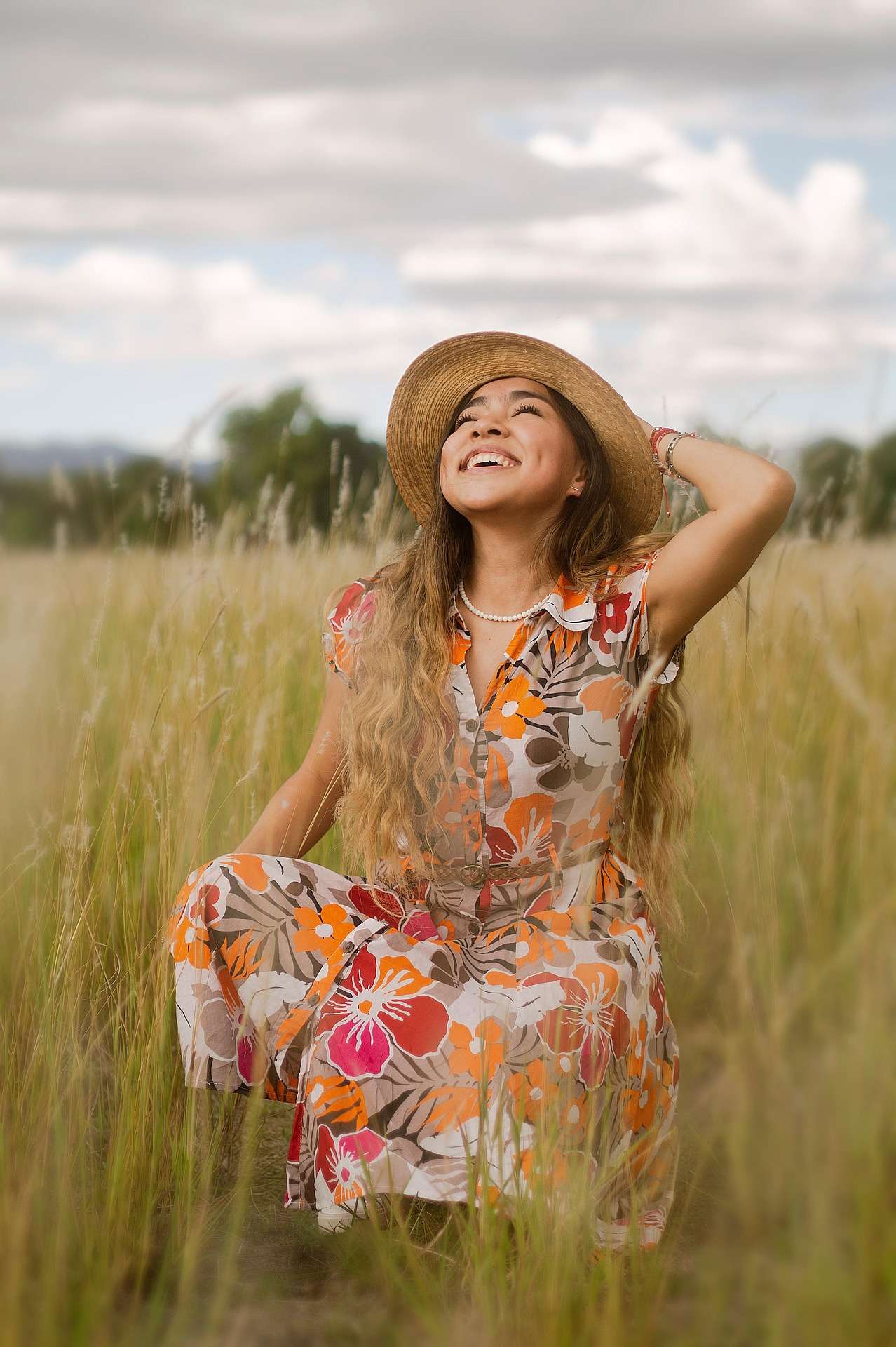 Young girl standing in a grassy field.